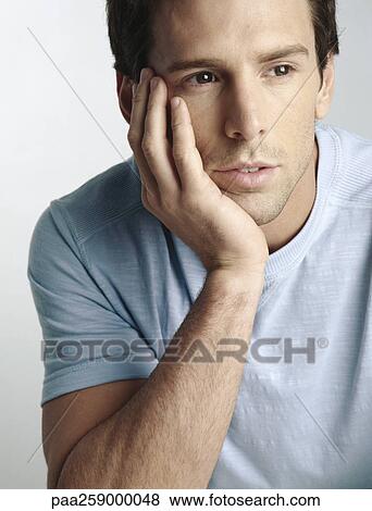 Young man holding head with hand, looking away, close-up View Large Photo Image Stock Photo - Young man holding head with hand, looking away, close-up. Fotosearch