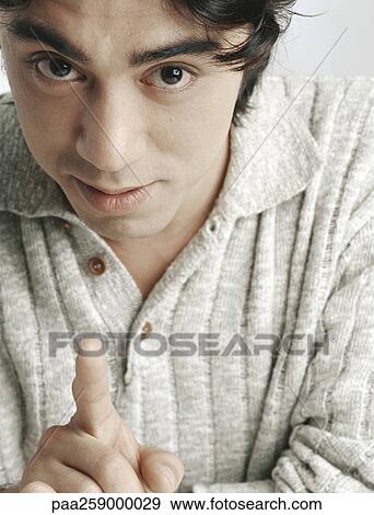 Young man looking and pointing at camera, close-up View Large Photo Image Stock Photo - Young man looking and pointing at camera, close-up. Fotosearch