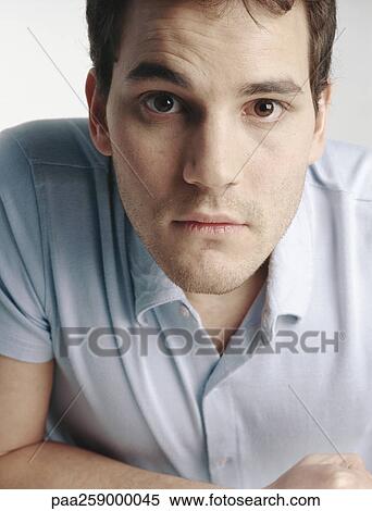 Young man with eyebrow raised looking at camera, close-up View Large Photo Image Stock Photography - Young man with eyebrow raised looking at camera, close-up. Fotosearch