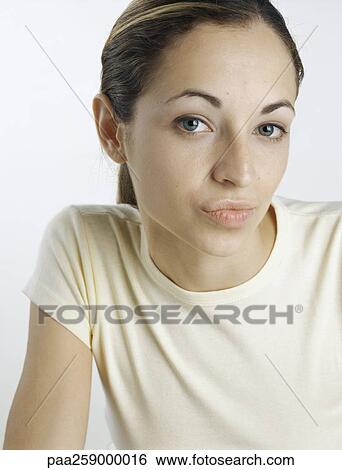 Young woman looking at camera with lips puckered, close-up View Large Photo Image Stock Photograph - Young woman looking at camera with lips puckered, close-up. Fotosearch