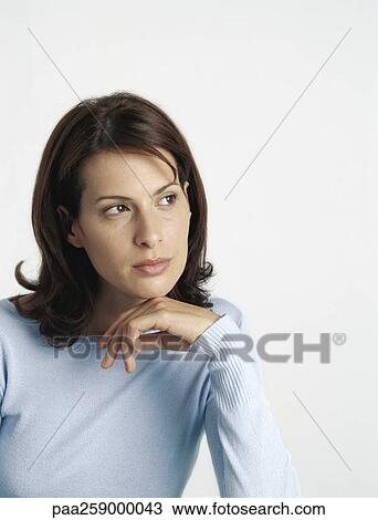 Young woman looking to the side, hand under chin View Large Photo Image Stock Image - Young woman looking to the side, hand under chin. Fotosearch