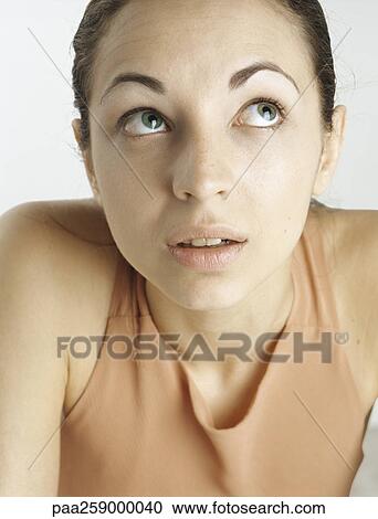 Young woman looking up with raised eyebrows, close-up View Large Photo Image Stock Image - Young woman looking up with raised eyebrows, close-up. Fotosearch