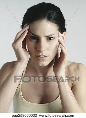 Young woman with hands on head, close-up View Large Photo Image Stock Image - Young woman with hands on head, close-up. Fotosearch