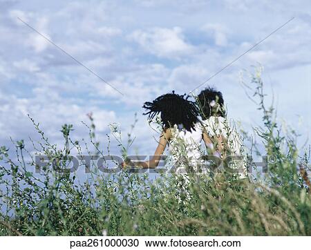 Rear view of young man and young woman through tall grass View Large Photo Image Stock Image - Rear view of young man and young woman through tall grass. Fotosearch