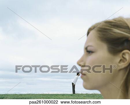 Stock Image - Side view of woman's face blurred in foreground, man next to woman's lips in distance. Fotosearch