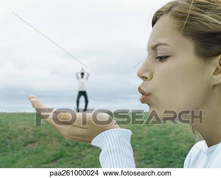 Woman blowing a kiss, man in distant background, optical illusion View Large Photo Image Picture - Woman blowing a kiss, man in distant background, optical illusion. Fotosearch