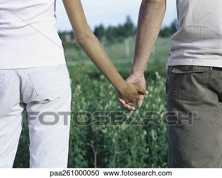 Young couple holding hands, mid section View Large Photo Image Stock Image - Young couple holding hands, mid section. Fotosearch