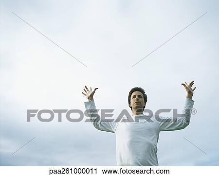 Young man with hands up in air in front of overcast sky View Large Photo Image Stock Image - Young man with hands up in air in front of overcast sky. Fotosearch