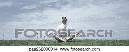 Man in business clothes sitting in lotus position on grass with head back and eyes closed, front view View Large Photo Image Picture - Man in business clothes sitting in lotus position on grass with head back and eyes closed, front view. Fotosearch