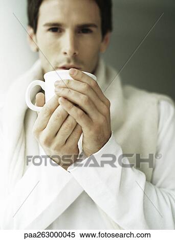Stock Photography - Man holding up mug with both hands. Fotosearch