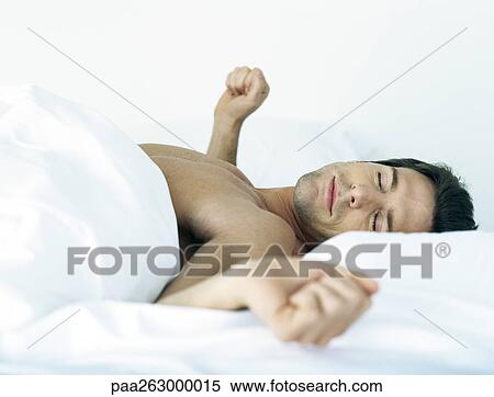 Man lying shirtless on bed, stretching arms to the side, eyes closed View Large Photo Image Stock Photography - Man lying shirtless on bed, stretching arms to the side, eyes closed. Fotosearch