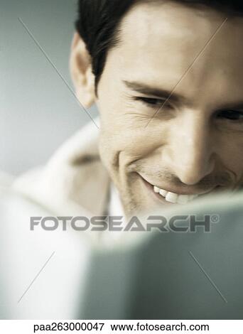 Man smiling behind open book, partial view, close-up View Large Photo Image Stock Photo - Man smiling behind open book, partial view, close-up. Fotosearch