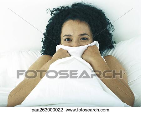 Woman in bed hiding part of face with covers View Large Photo Image Stock Image - Woman in bed hiding part of face with covers. Fotosearch