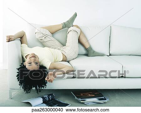 Woman Lying On Back On Sofa Head Hanging Upside Down Off Sofa