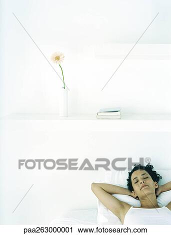Woman lying on bed with hands behind head View Large Photo Image Stock Image - Woman lying on bed with hands behind head. Fotosearch