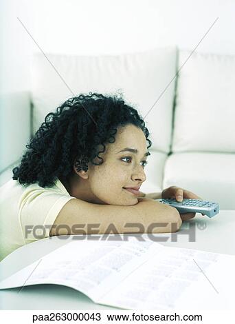 Woman with head resting on forearm, pointing remote control, side view View Large Photo Image Stock Image - Woman with head resting on forearm, pointing remote control, side view. Fotosearch