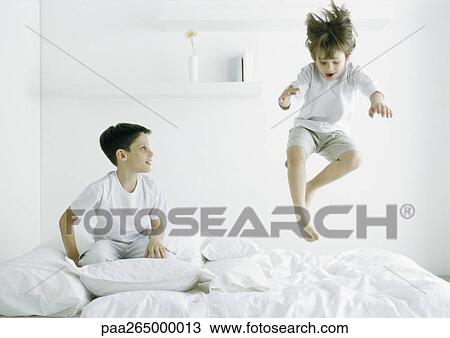 Boys on bed, one in mid air View Large Photo Image Stock Image - Boys on bed, one in mid air. Fotosearch
