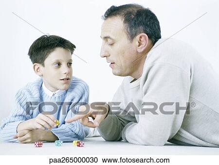 Father and son playing dice on floor View Large Photo Image Stock Image - Father and son playing dice on floor. Fotosearch