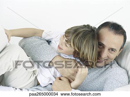 Father holding son in arms, laughing View Large Photo Image Picture - Father holding son in arms, laughing. Fotosearch