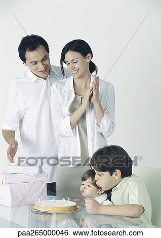Girl and boy blowing out candles on cake, parents standing, watching View Large Photo Image Stock Photograph - Girl and boy blowing out candles on cake, parents standing, watching. Fotosearch
