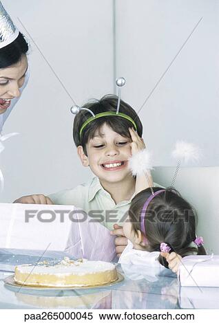 Stock Photography - Girl and boy with mother having birthday party. Fotosearch