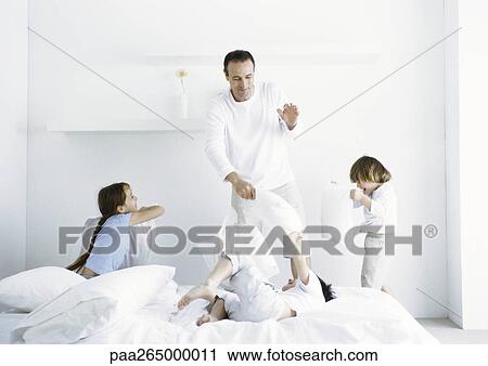 Girl and boys having pillow fight with man View Large Photo Image Stock Image - Girl and boys having pillow fight with man. Fotosearch