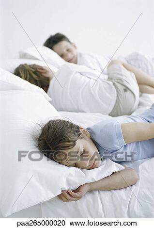 Girl and boys lying down on bed View Large Photo Image Stock Image - Girl and boys lying down on bed. Fotosearch