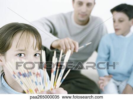 Girl holding out pick up sticks, father and boy in background View Large Photo Image Stock Photography - Girl holding out pick up sticks, father and boy in background. Fotosearch