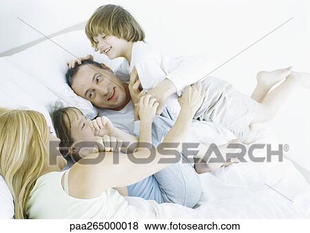 Parents with daughter and son in bed, smiling View Large Photo Image Stock Photo - Parents with daughter and son in bed, smiling. Fotosearch
