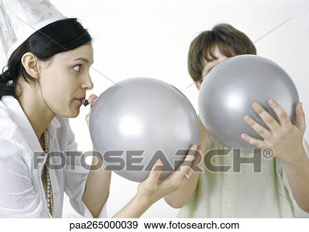 Woman and boy blowing up silver balloons View Large Photo Image Stock Photo - Woman and boy blowing up silver balloons. Fotosearch