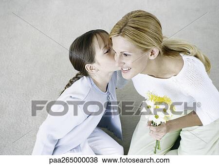 Woman holding bouquet of flowers, girl kissing her cheek View Large Photo Image Stock Photo - Woman holding bouquet of flowers, girl kissing her cheek. Fotosearch