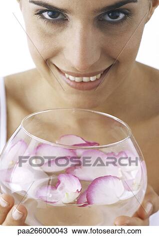 Woman holding bowl of water and rose petals, looking at camera, close-up View Large Photo Image Stock Image - Woman holding bowl of water and rose petals, looking at camera, close-up. Fotosearch