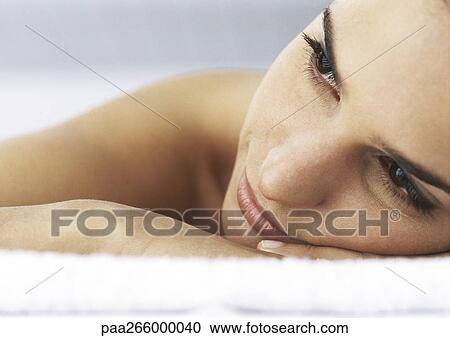 Stock Image - Woman laying head on hands, looking away, close-up. Fotosearch