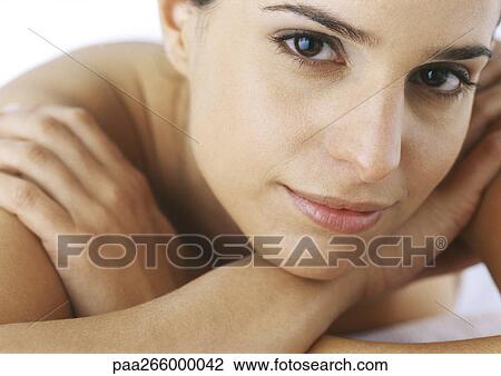 Woman looking at camera, arms crossed under chin, close-up View Large Photo Image Stock Image - Woman looking at camera, arms crossed under chin, close-up. Fotosearch