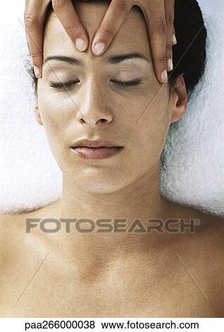 Stock Photo - Woman massaging second woman's forehead, close-up. Fotosearch