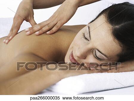 Woman massaging woman lying on stomach with eyes closed View Large Photo Image Stock Photography - Woman massaging woman lying on stomach with eyes closed. Fotosearch