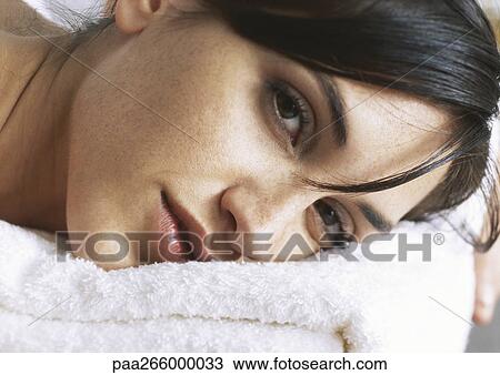 Woman with head on folded towel, looking at camera, close-up View Large Photo Image Stock Image - Woman with head on folded towel, looking at camera, close-up. Fotosearch