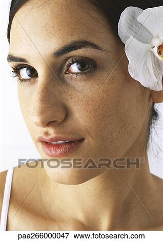 Woman with orchid behind ear looking at camera, close-up View Large Photo Image Stock Photo - Woman with orchid behind ear looking at camera, close-up. Fotosearch