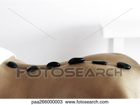 Woman's back with black stones lined up along spine, close-up View Large Photo Image Stock Image - Woman's back with black stones lined up along spine, close-up. Fotosearch