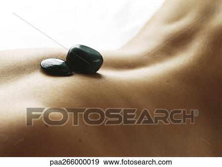 Woman's bare back with black stones on spine, close-up View Large Photo Image Stock Photo - Woman's bare back with black stones on spine, close-up. Fotosearch