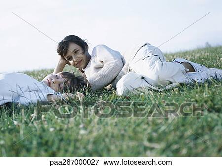 Stock Photo - Boy and girl lying on grass. Fotosearch