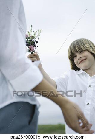 Boy handing woman bouquet of wildflowers View Large Photo Image Stock Photography - Boy handing woman bouquet of wildflowers. Fotosearch