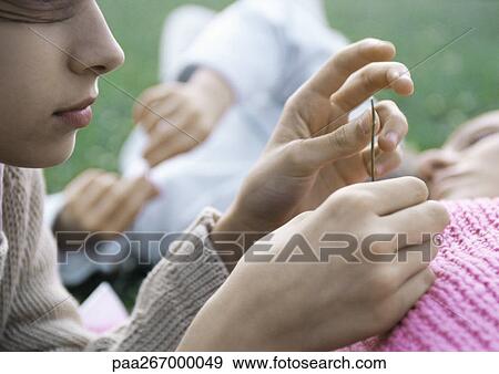 Girl holding blade of grass, mother and brother lying on grass View Large Photo Image Stock Photo - Girl holding blade of grass, mother and brother lying on grass. Fotosearch