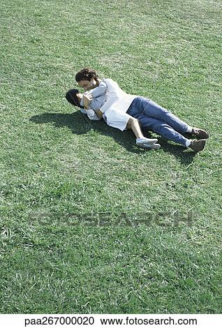 Man and daughter lying on grass in sun, high angle view View Large Photo Image Stock Image - Man and daughter lying on grass in sun, high angle view. Fotosearch
