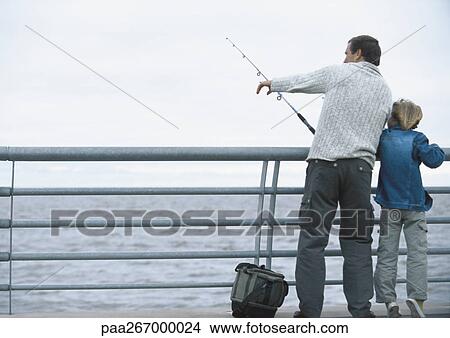 Man and son fishing on pier, man pointing, full length View Large Photo Image Picture - Man and son fishing on pier, man pointing, full length. Fotosearch