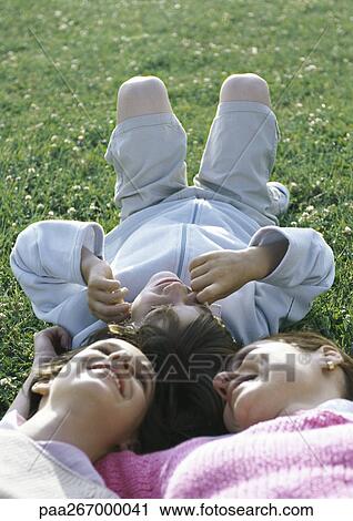 Mother lying on grass with boy and girl, head to head View Large Photo Image Stock Image - Mother lying on grass with boy and girl, head to head. Fotosearch