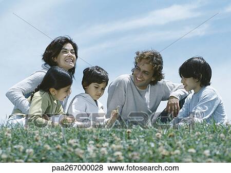 Parents sitting with boys and girl on grass View Large Photo Image Stock Photo - Parents sitting with boys and girl on grass. Fotosearch