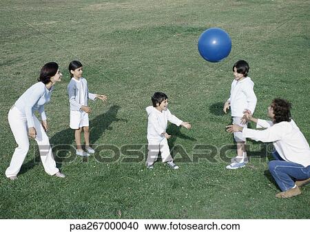 Parents with boys and girl playing ball on grass, full length View Large Photo Image Stock Image - Parents with boys and girl playing ball on grass, full length. Fotosearch