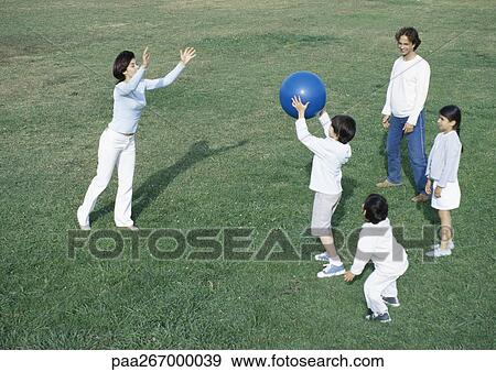 Parents with boys and girl playing ball on grass, full length View Large Photo Image Stock Photo - Parents with boys and girl playing ball on grass, full length. Fotosearch