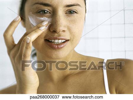 Woman applying moisturizer beneath eye View Large Photo Image Stock Photo - Woman applying moisturizer beneath eye. Fotosearch